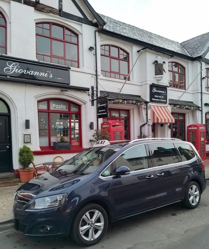 AB Cabs Knutsford taxi waiting for a pickup outside Giovanni's Italian Restaurant on King Street.